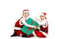 Adorable happy laughing boys in santa clothes holding Christmas gift box. Isolated white background. Royalty Free Stock Photo