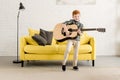 adorable happy little boy playing guitar