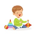 Adorable happy little boy sitting on the floor playing with toys, colorful character vector Illustration Royalty Free Stock Photo