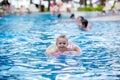 Adorable happy little child, toddler boy, having fun relaxing and playing in a pool in inflatable ring on sunny day during summer Royalty Free Stock Photo