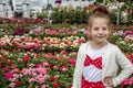 Adorable Happy Little Girl in a Flower Shop`s Garden Royalty Free Stock Photo