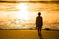 Adorable happy little girl walking on white beach at sunset. Royalty Free Stock Photo