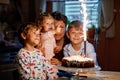 Adorable happy little kid boy celebrating his birthday. Child blowing candles on cake. Father, brother and baby sister Royalty Free Stock Photo