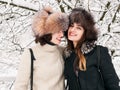 Adorable happy young brunette women girlfriends in fur hats having fun snowy winter park forest in nature Royalty Free Stock Photo