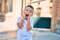 Adorable hispanic boy with hands on face smiling happy at the city