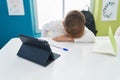 Adorable hispanic boy student tired leaning on the desk at classroom Royalty Free Stock Photo