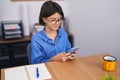 Adorable hispanic girl business worker using smartphone working at office Royalty Free Stock Photo