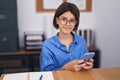 Adorable hispanic girl business worker using smartphone working at office Royalty Free Stock Photo