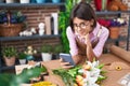 Adorable hispanic girl florist smiling confident using smartphone at flower shop Royalty Free Stock Photo