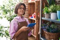 Adorable hispanic girl florist smiling confident using touchpad at flower shop Royalty Free Stock Photo