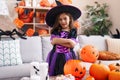 Adorable hispanic girl having halloween party standing with arms crossed gesture at home