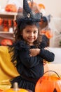 Adorable hispanic girl having halloween party standing with arms crossed gesture at home