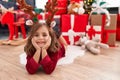 Adorable hispanic girl smiling confident lying on floor by christmas tree at home Royalty Free Stock Photo