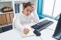 Adorable hispanic girl student using computer writing notes at classroom Royalty Free Stock Photo