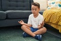 Adorable hispanic toddler doing yoga exercise sitting on floor at home Royalty Free Stock Photo