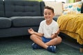 Adorable hispanic toddler doing yoga exercise sitting on floor at home Royalty Free Stock Photo