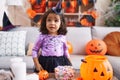 Adorable hispanic toddler having halloween party standing at home