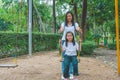 Adorable and Holiday Concept : Woman and child feeling funny and happiness on a swing at playground. Royalty Free Stock Photo