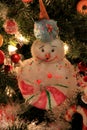 Adorable holiday snowman ornaments and lights on Christmas tree