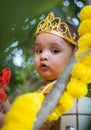 adorable infant dressed as hindu god krishna cute facial expression playing at tree at janmashtami