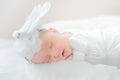 Adorable infant girl in white pajama sleeping on white cloth mattress. newborn baby having day nap in parent`s bed Royalty Free Stock Photo