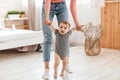 Adorable infant kid making first steps with mother& x27;s help, little baby holding mom& x27;s hands while walking in Royalty Free Stock Photo