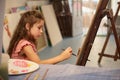 Adorable inspired Caucasian child, little girl artist painting on canvas doing some art projects on a creative workshop