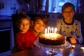 Adorable kid boy celebrating tenth birthday. Baby sister child and two kids boys brothers blowing together candles on Royalty Free Stock Photo