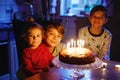 Adorable kid boy celebrating tenth birthday. Baby sister child and two kids boys brothers blowing together candles on Royalty Free Stock Photo