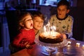 Adorable kid boy celebrating tenth birthday. Baby sister child and two kids boys brothers blowing together candles on Royalty Free Stock Photo