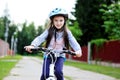 Adorable kid girl in blue helmet riding her bike Royalty Free Stock Photo