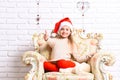 Adorable kid has rest on furniture. Girl with happy face