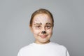 Adorable kid with paint on face smiling, portrait. Helloween on birthday party with animators makeup concept