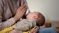 Adorable kid sucking milk formula from bottle in mommy arms, orthodontic binky