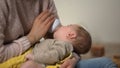 Adorable kid sucking milk formula from bottle in mommy arms, orthodontic binky