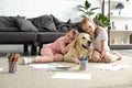 adorable kids hugging golden retriever dog while sitting on floor