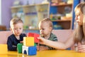 Adorable kids playing with constructor on table in kindergarten Royalty Free Stock Photo