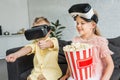 adorable kids using virtual reality headsets and eating popcorn Royalty Free Stock Photo