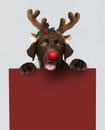 Adorable Labrador Retriever puppy wearing a Christmas reindeer headband holding a red board mockup
