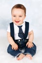 Adorable laughing baby with braces and tie