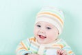 Adorable laughing baby wearing a warm knitted jack