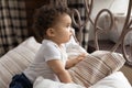 Adorable little african american baby boy or girl creeping on bed. Royalty Free Stock Photo