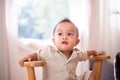 Adorable asian baby boy sitting on chair in bedroom,Happy and laughing new born kid Royalty Free Stock Photo