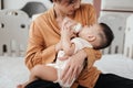 Adorable little Asian baby sleep during drinking milk from baby bottle. Asian mother holding adorable her son and feeding milk Royalty Free Stock Photo