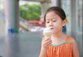 Adorable little Asian child girl enjoy eating ice cream cone Royalty Free Stock Photo