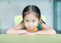 Adorable little Asian child girl lying and playing rubber toy in children room