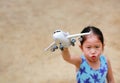 Adorable little Asian child girl playing with a toy airplane in the garden Royalty Free Stock Photo