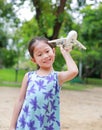 Adorable little Asian child girl playing with a toy airplane in the garden Royalty Free Stock Photo