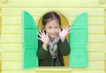 Adorable little Asian child girl playing with window toy playhouse in playground Royalty Free Stock Photo