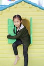 Adorable little Asian child girl playing with window toy playhouse in playground Royalty Free Stock Photo